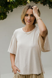 Model Tegan wearing size 8 of the Flutter By Tee in colour Natural, from the front, cropped image