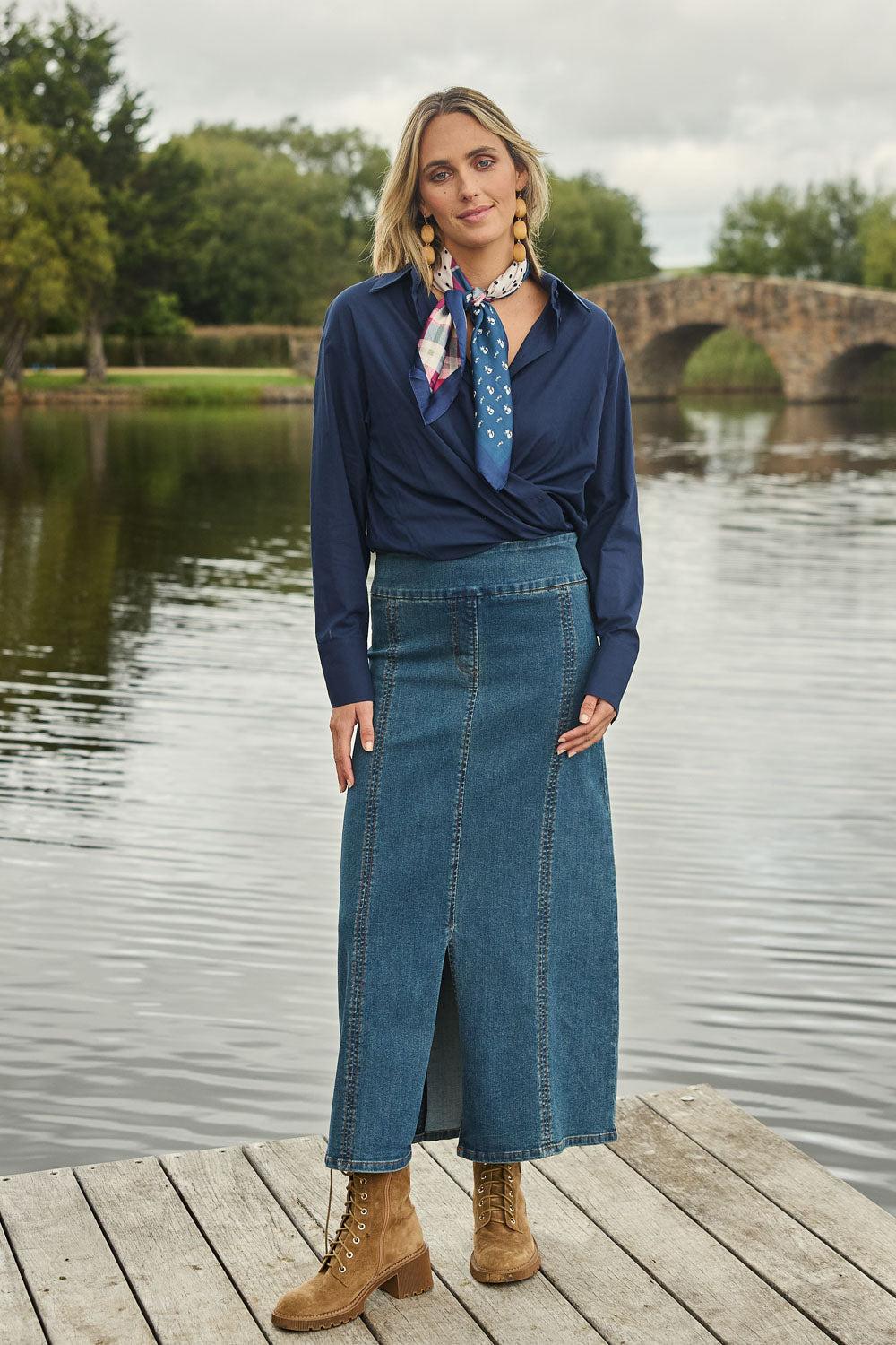 Model Tegan wearing size 10 of the Easy As Pull On Panel Skirt in colour Darkdenim (Blue), from the front, showing the whole outfit