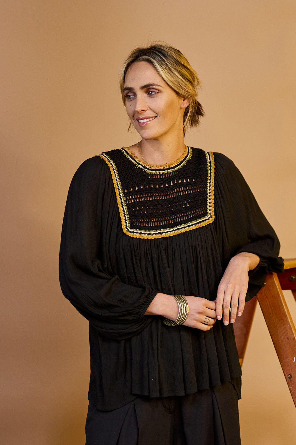 Model Tegan wearing size 10 of the Ebb And Flow Crochet Detail Top in colour Black (Black), from the front, showing the whole outfit