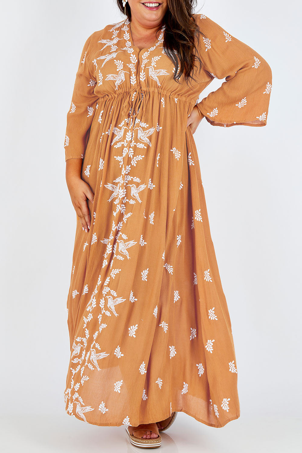 Model Stacey wearing size 16 of the Dancing With Birds Dress in colour Golden, from the front, cropped image