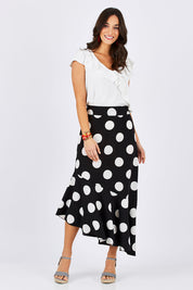 Model Georgia wearing size 10 of the Bellissimo Skirt in colour BlackDot (Black), from the front, showing the whole outfit