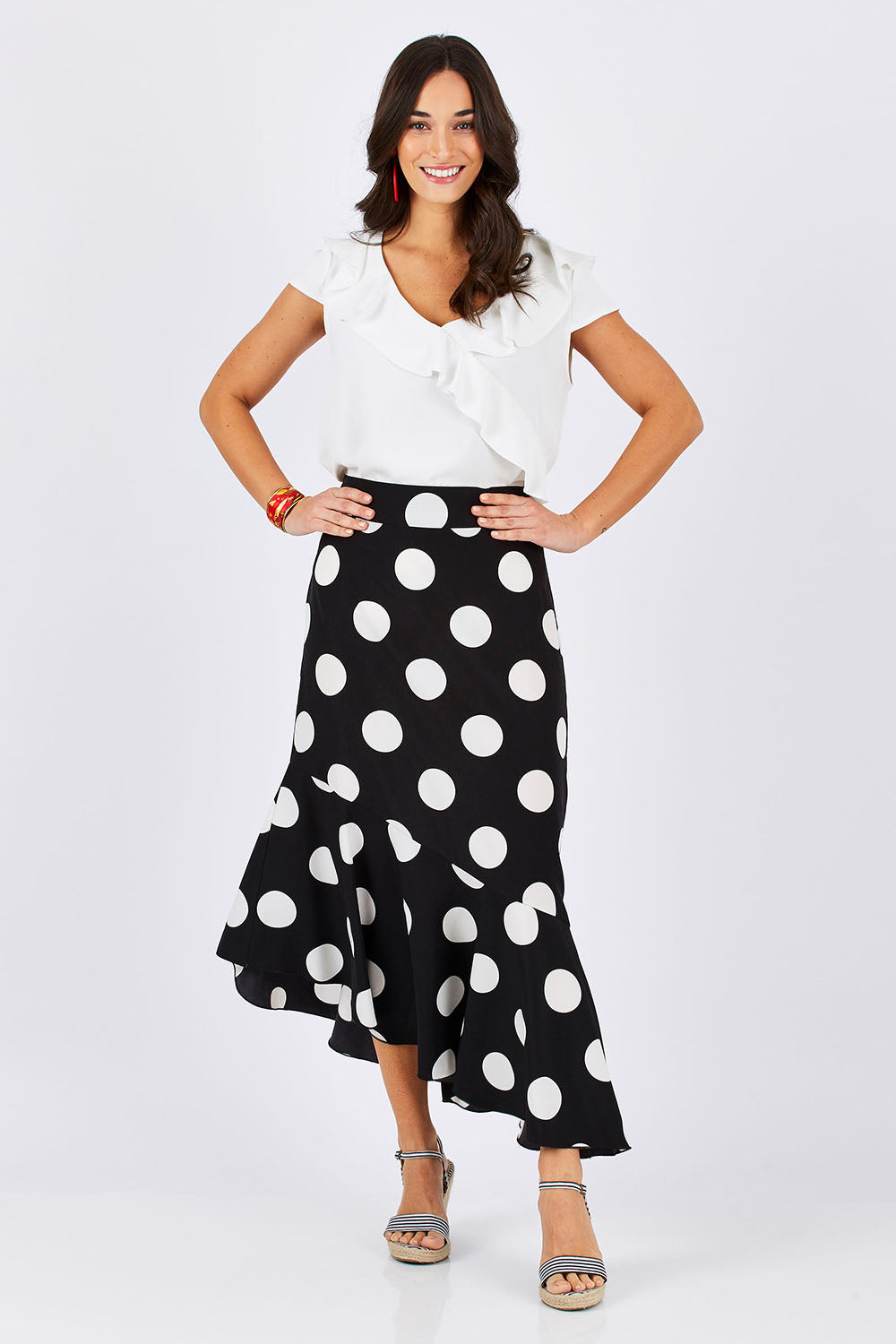Model Georgia wearing size 10 of the Bellissimo Skirt in colour BlackDot (Black), from the front, showing the whole outfit