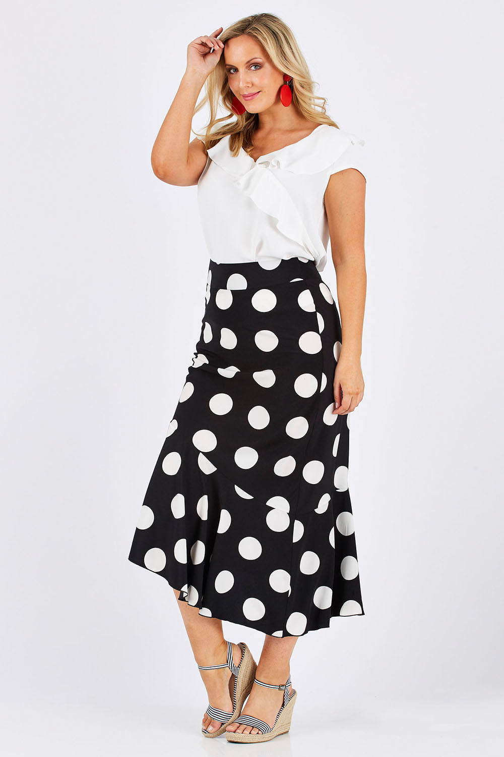 Model Jess wearing size 12 of the Bellissimo Skirt in colour BlackDot (Black), from the front, showing the whole outfit