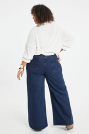 Model Alexis wearing size 16 of the Happy Me Wide Leg Jeans in colour Darkdenim (Blue), from the back