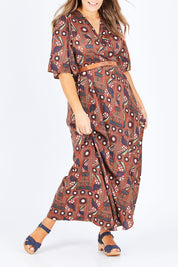 Model Natalia wearing size 14 of the Maximum Impact Dress in colour Rust, from the front, cropped image