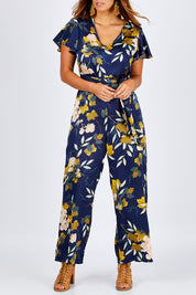 Model Laura wearing size 12 of the Sunday Picnic Jumpsuit in colour NavyFluer (Blue), from the front, cropped image