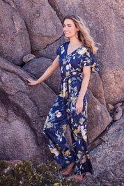 Model Marnee wearing size 10 of the Sunday Picnic Jumpsuit in colour NavyFluer (Blue), from the front, showing the whole outfit