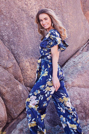 Model Marnee wearing size 10 of the Sunday Picnic Jumpsuit in colour NavyFluer (Blue), from the front, showing the whole outfit