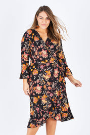 Model Natalia wearing size 14 of the Swanning Around Wrap Dress in colour BlackOrch (Black), from the front, cropped image