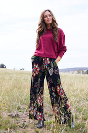 Model Emma wearing size 10 of the Falling Leaves Wide Leg Pant in colour Black (Black), from the front, showing the whole outfit
