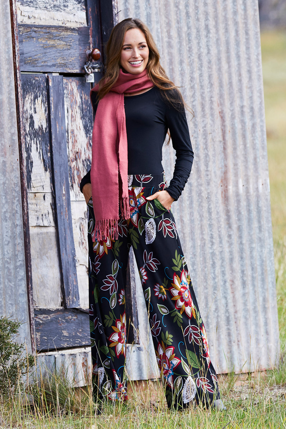 Model Emma wearing size 10 of the Falling Leaves Wide Leg Pant in colour Black (Black), from the front, showing the whole outfit
