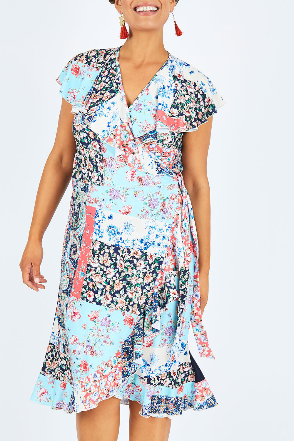 Model Shanaya wearing size 14 of the Life Is Beautiful Wrap Dress in colour Fleurpatch (Blue), from the front, cropped image