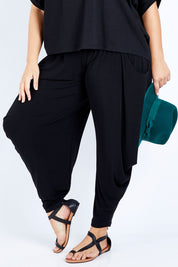 Model Jess wearing size 16 of The Wanderer In Me Travel Pant in colour Black (Black), from the front, cropped image