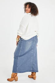 Model Alexis wearing size 16 of the Dusty Footprints Skirt in colour Denim (Blue), from the back