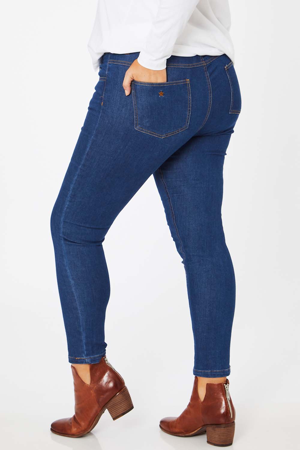 Model Jess wearing size 14 of the Follow Me Home Button Jeggings in colour Denim (Black), from the back