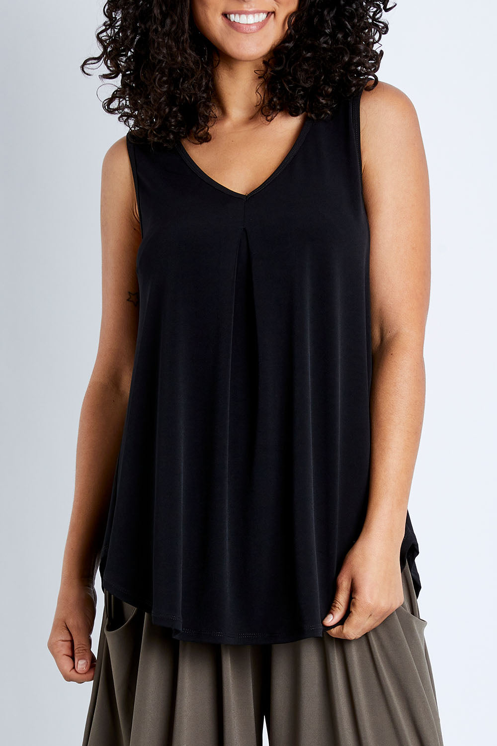 Model Pamela wearing size 10 of The Wanderer In Me V Neck Travel Singlet in colour Black (Black), from the front, cropped image