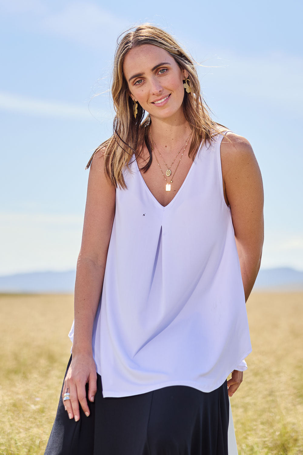Model Tegan wearing size 10 of The Wanderer In Me V Neck Travel Singlet in colour White (White), from the front, showing the whole outfit
