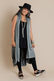 Model Nadine wearing size 10 of the Softly Swinging Bamboo Vest in colour Fern (Green), from the front, showing the whole outfit