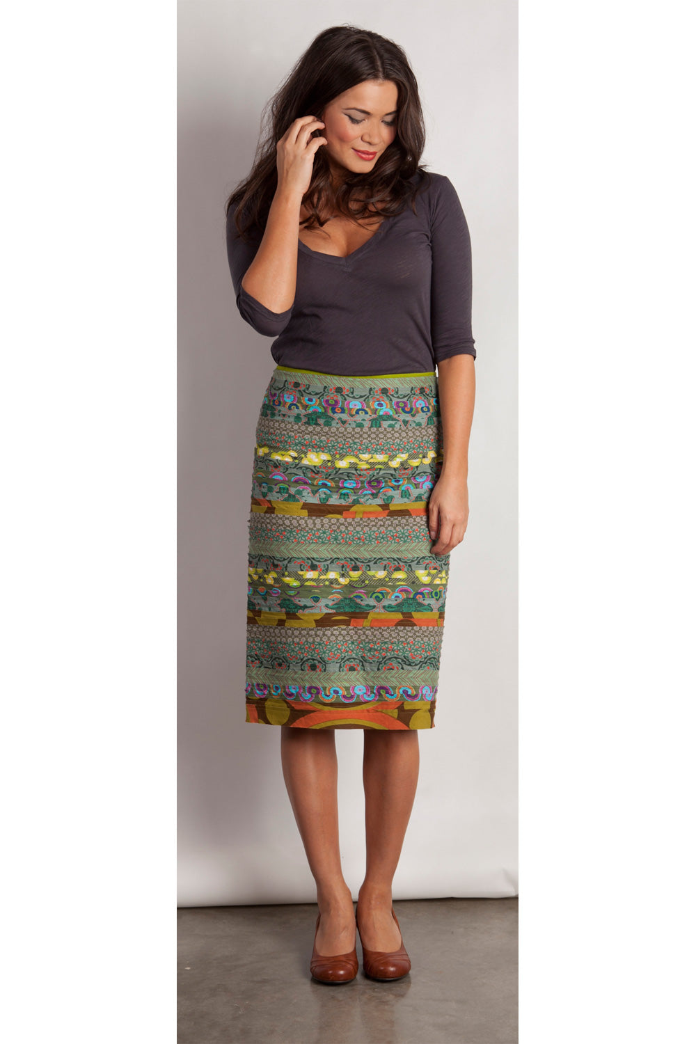 A model wearing the Pencil Cleo Skirt in colour Green (Green), from the front, showing the whole outfit