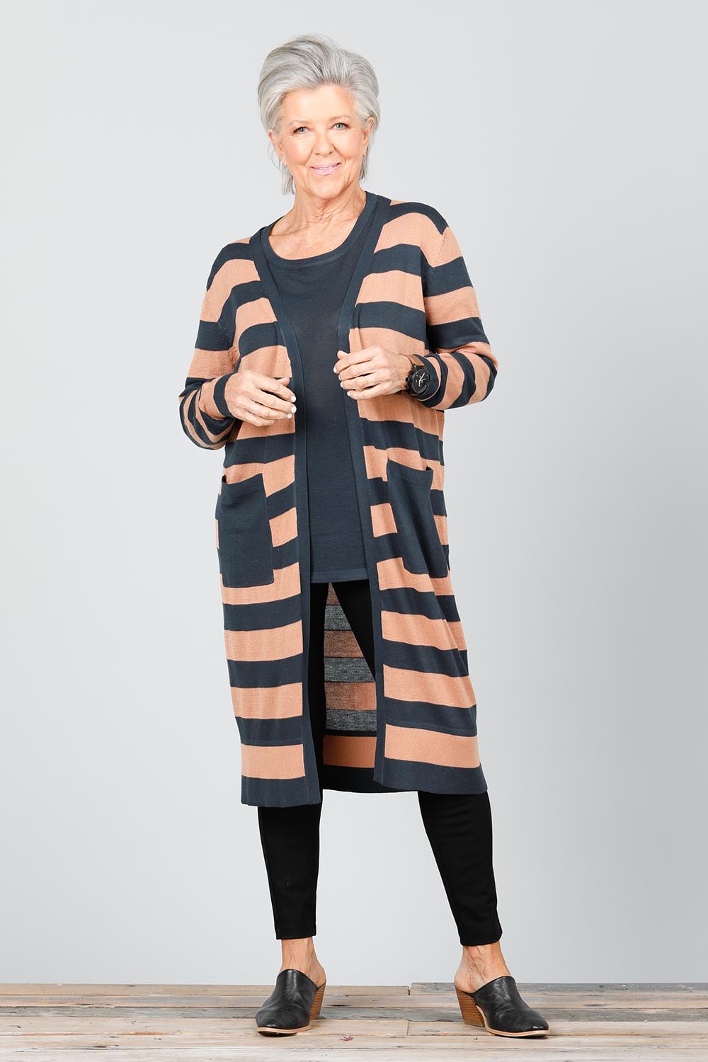 A model wearing the St Moritz Stripe Cardigan in colour Charclay (Grey), from the front, showing the whole outfit
