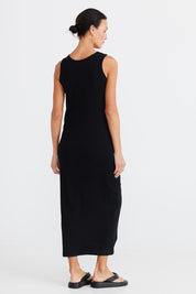 A model wearing the Carrie Dress in colour Black (Black), from the back