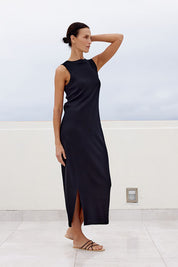 A model wearing the Carrie Dress in colour Black (Black), from the front, showing the whole outfit