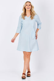 Model Jess wearing size M of the Gela Dress in colour Sky (Blue), from the front, showing the whole outfit