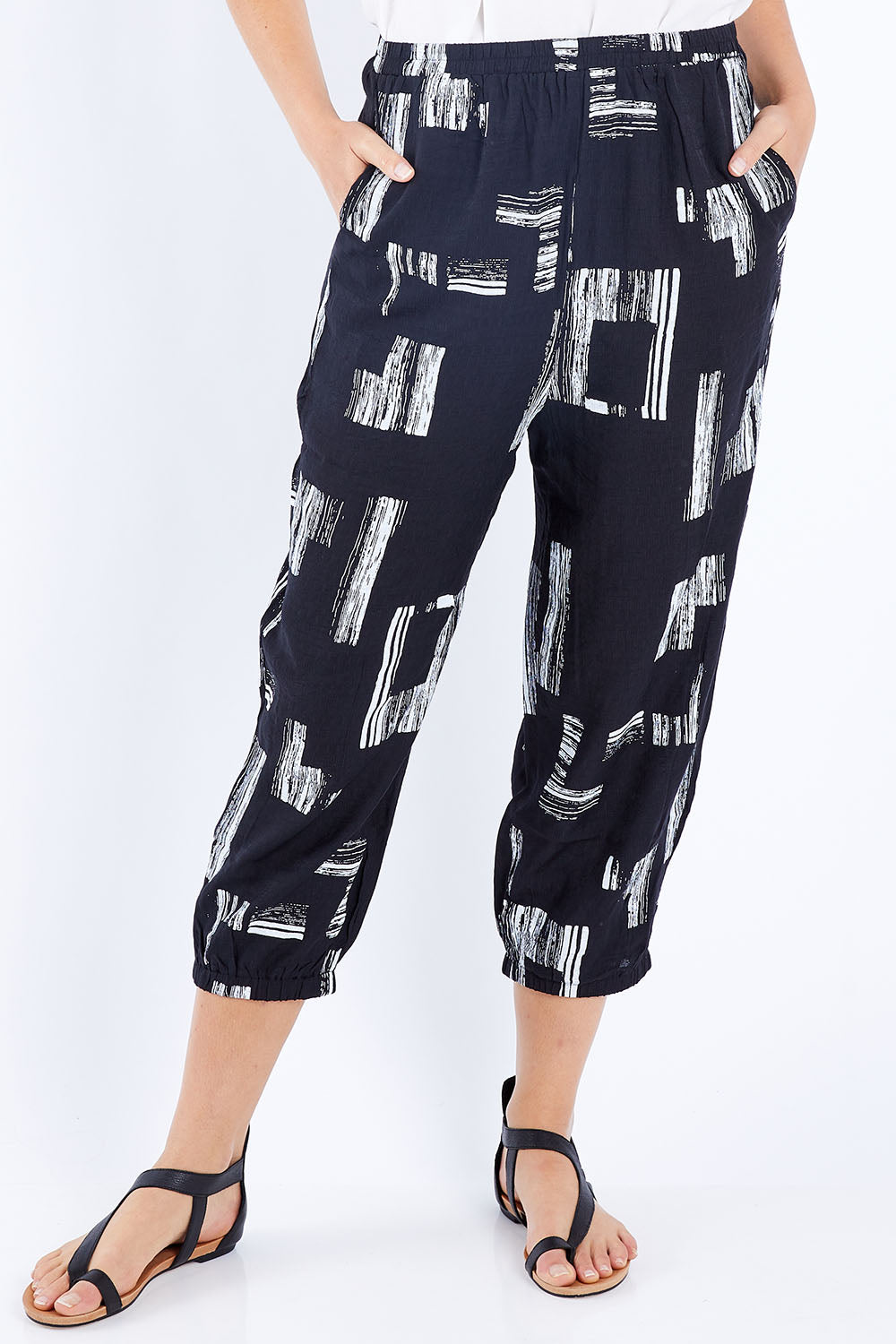 Model Madeline wearing size S of the Line Print Gathered Hem Pants in colour Blackwhite (Black), from the front, cropped image