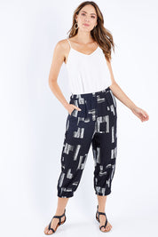 Model Madeline wearing size S of the Line Print Gathered Hem Pants in colour Blackwhite (Black), from the front, showing the whole outfit