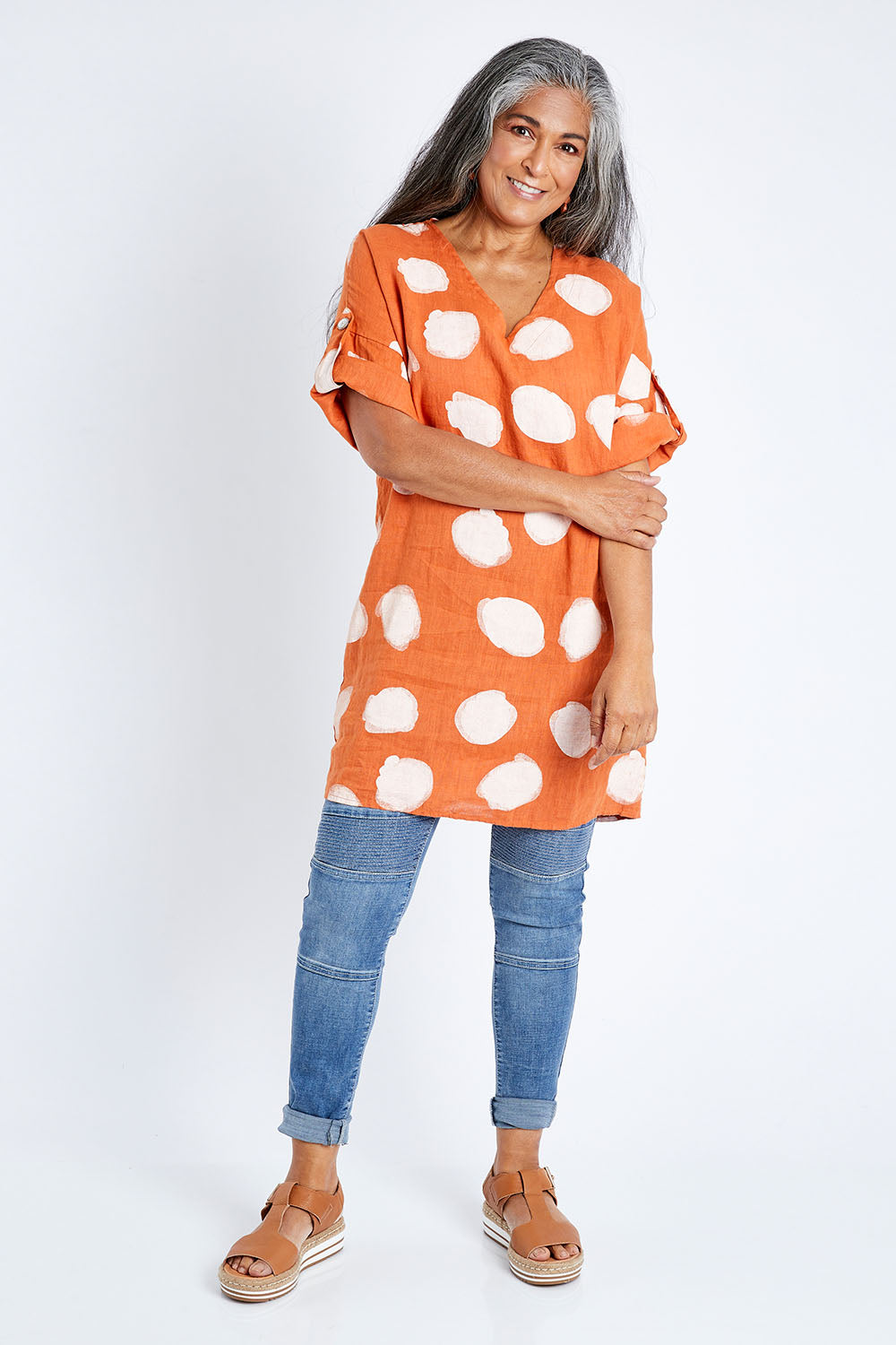 Model Nadine wearing size S of the Blurred Spot Tunic in colour Orange, from the front, showing the whole outfit