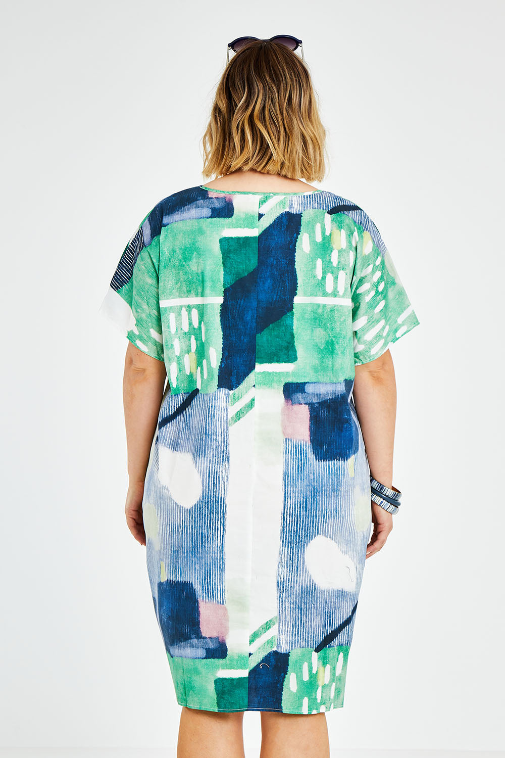 Model Jess wearing size L of the Pocket Print Dress in colour Multi (Green), from the back