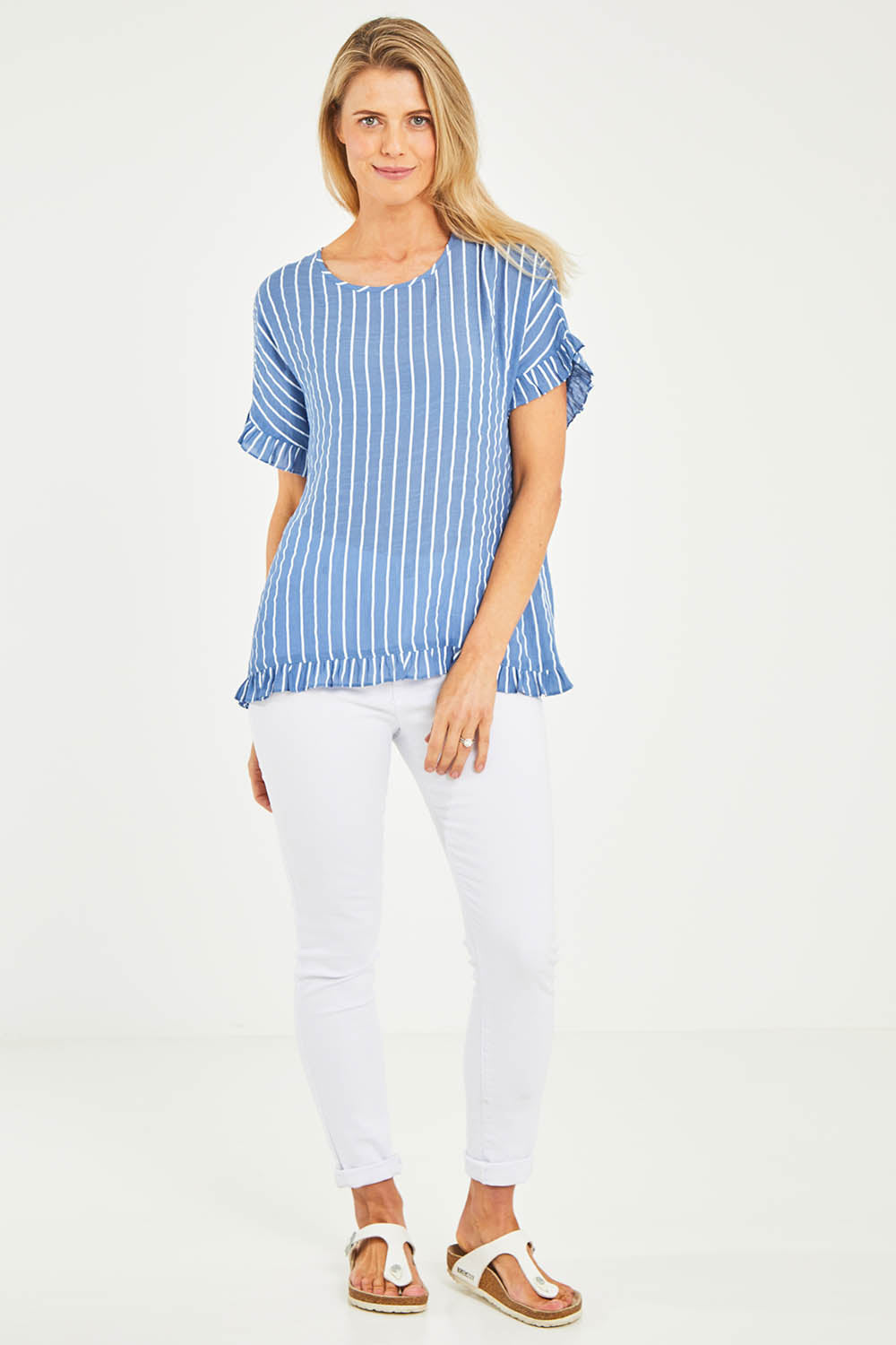 Model Kelly wearing size S of the Stripe Frilled Hem Top in colour Denim (Blue), from the front, showing the whole outfit
