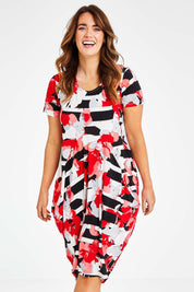 Model Laura wearing size 14 of the Cap Sleeve Bounce Dress in colour Red (Red), from the front, cropped image