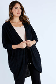 Model Madeline wearing size 10 of the Cocoon Cardy in colour Black (Black), from the front, cropped image
