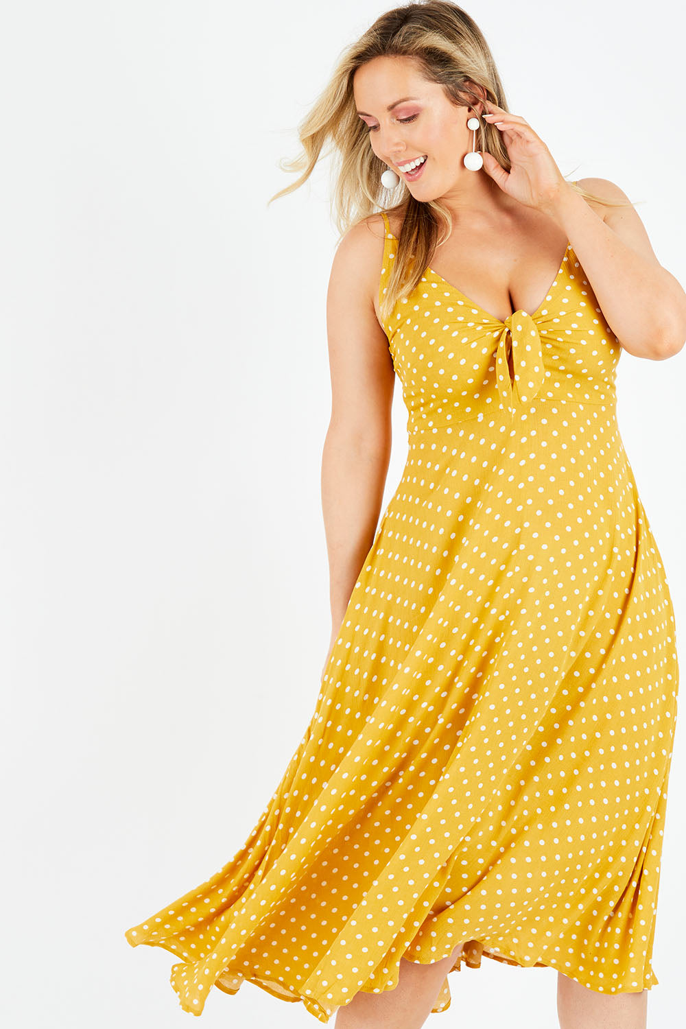 Model Jess wearing size L of the Zuma Maxi in colour Saffron, from the front, cropped image