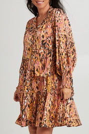 Model Katie wearing size S of the Mayan Dress in colour Ochre, from the front, cropped image