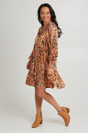 Model Katie wearing size S of the Mayan Dress in colour Ochre, from the front, showing the whole outfit