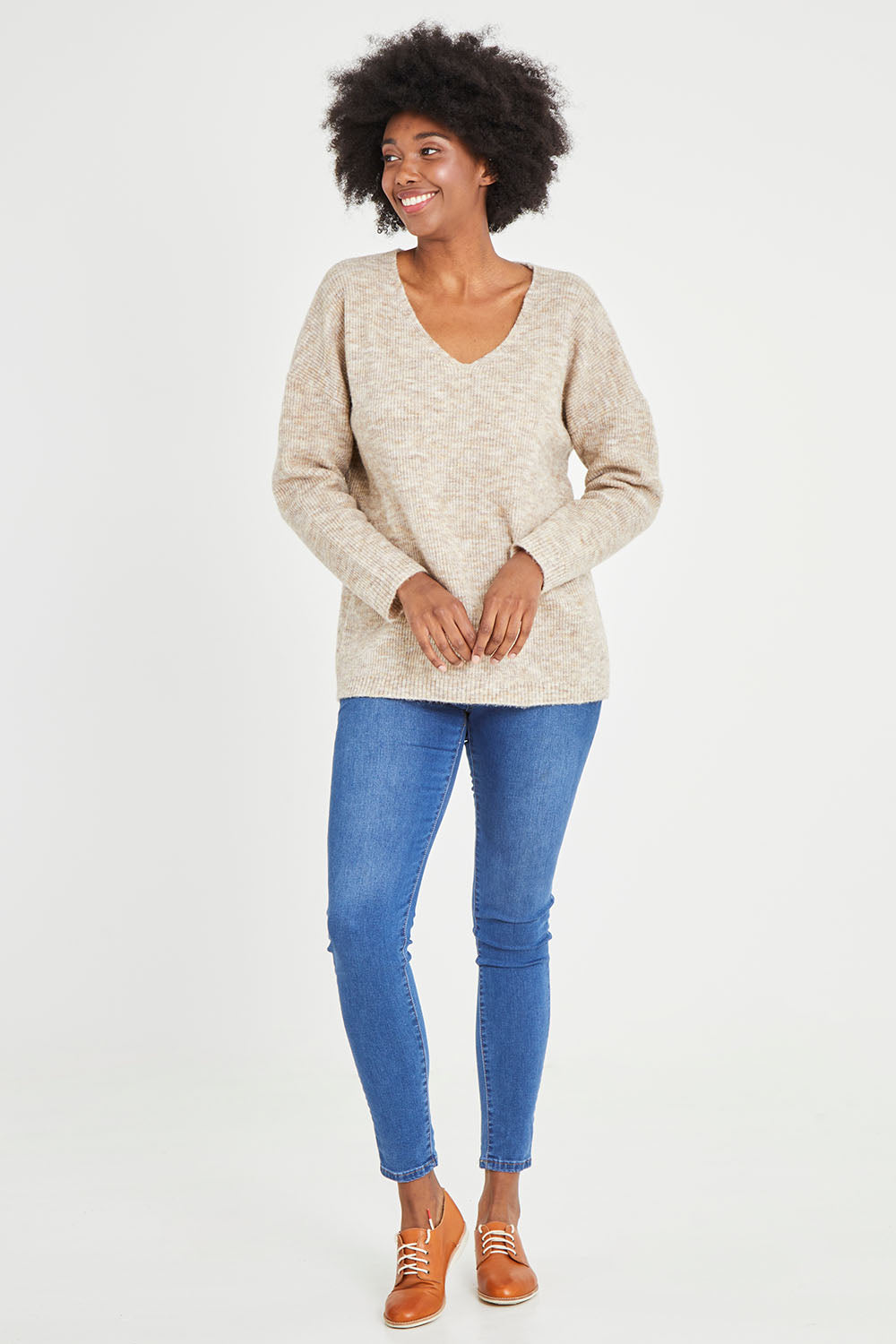 Model Aiyana wearing size S of the Verity V Neck Knit in colour Oatmeal, from the front, showing the whole outfit