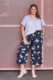 A model wearing the Fruity Tootie Pant in colour Navymulti (Blue), from the front, showing the whole outfit