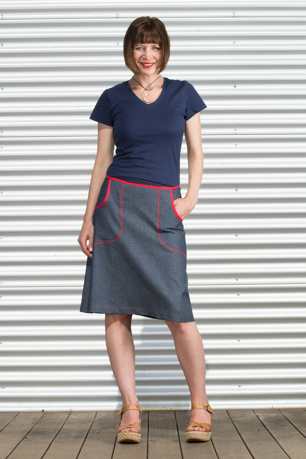 A model wearing the Denim Pocket Skirt in colour Denim (Blue), from the front, showing the whole outfit