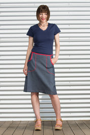 A model wearing the Denim Pocket Skirt in colour Denim (Blue), from the front, showing the whole outfit
