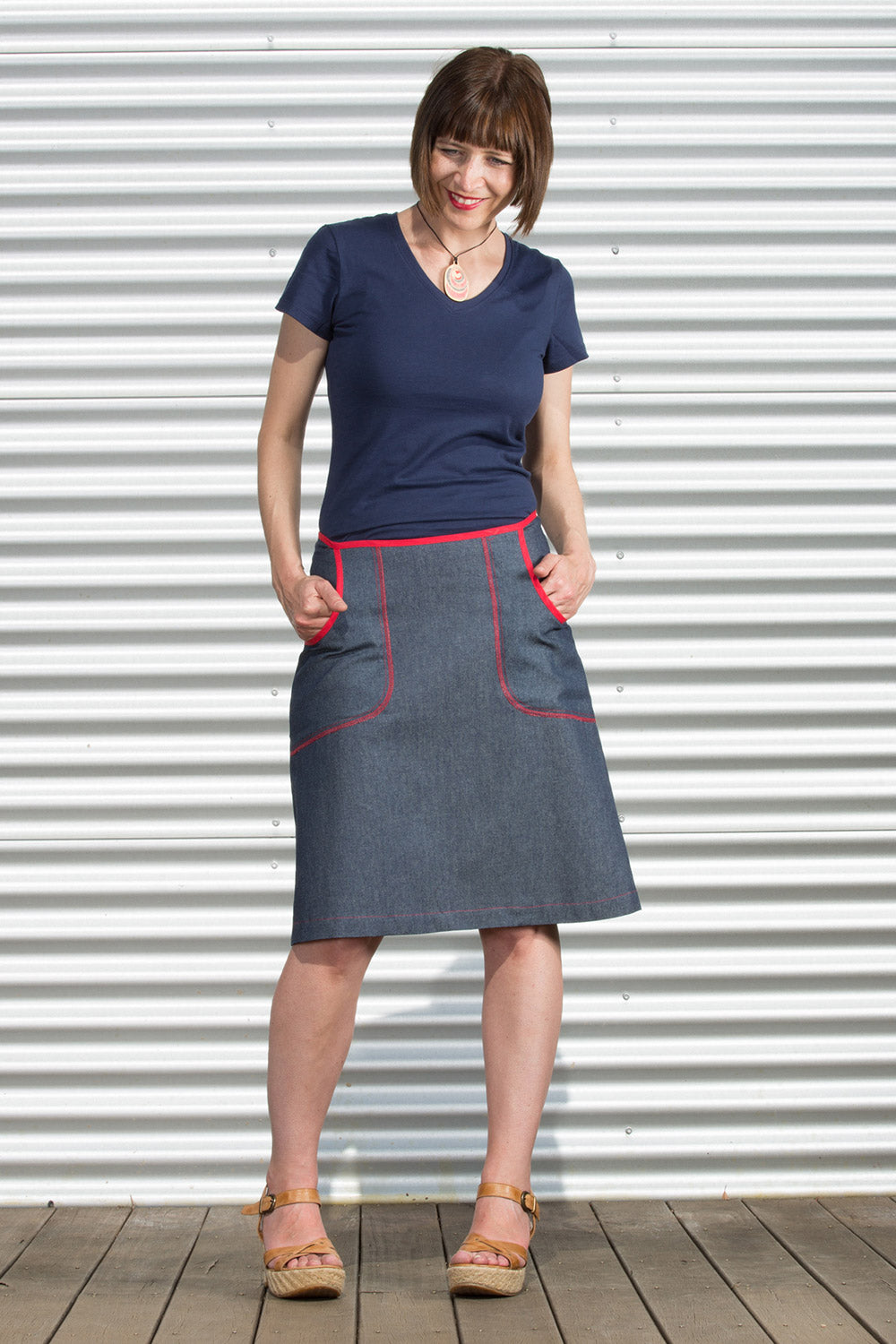 A model wearing the Denim Pocket Skirt in colour Denim (Blue), from the front, showing the whole outfit