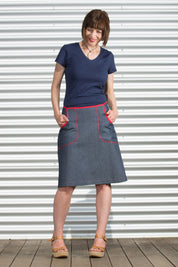 A model wearing the Denim Pocket Skirt in colour Denim (Blue), from the front, showing the whole outfit