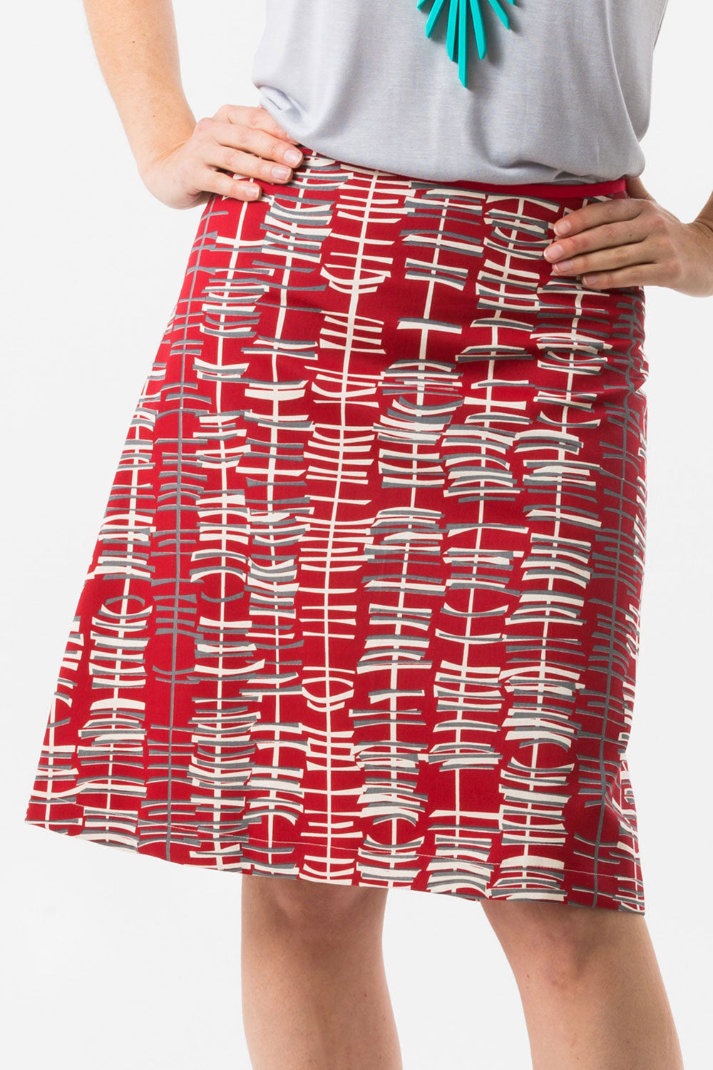 A model wearing the Sticks A line Skirt in colour RedGrey (Red), from the front, cropped image