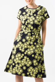 A model wearing the Glow Emma Dress in colour IndigoLem (Blue), from the front, cropped image