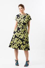 A model wearing the Glow Emma Dress in colour IndigoLem (Blue), from the front, showing the whole outfit