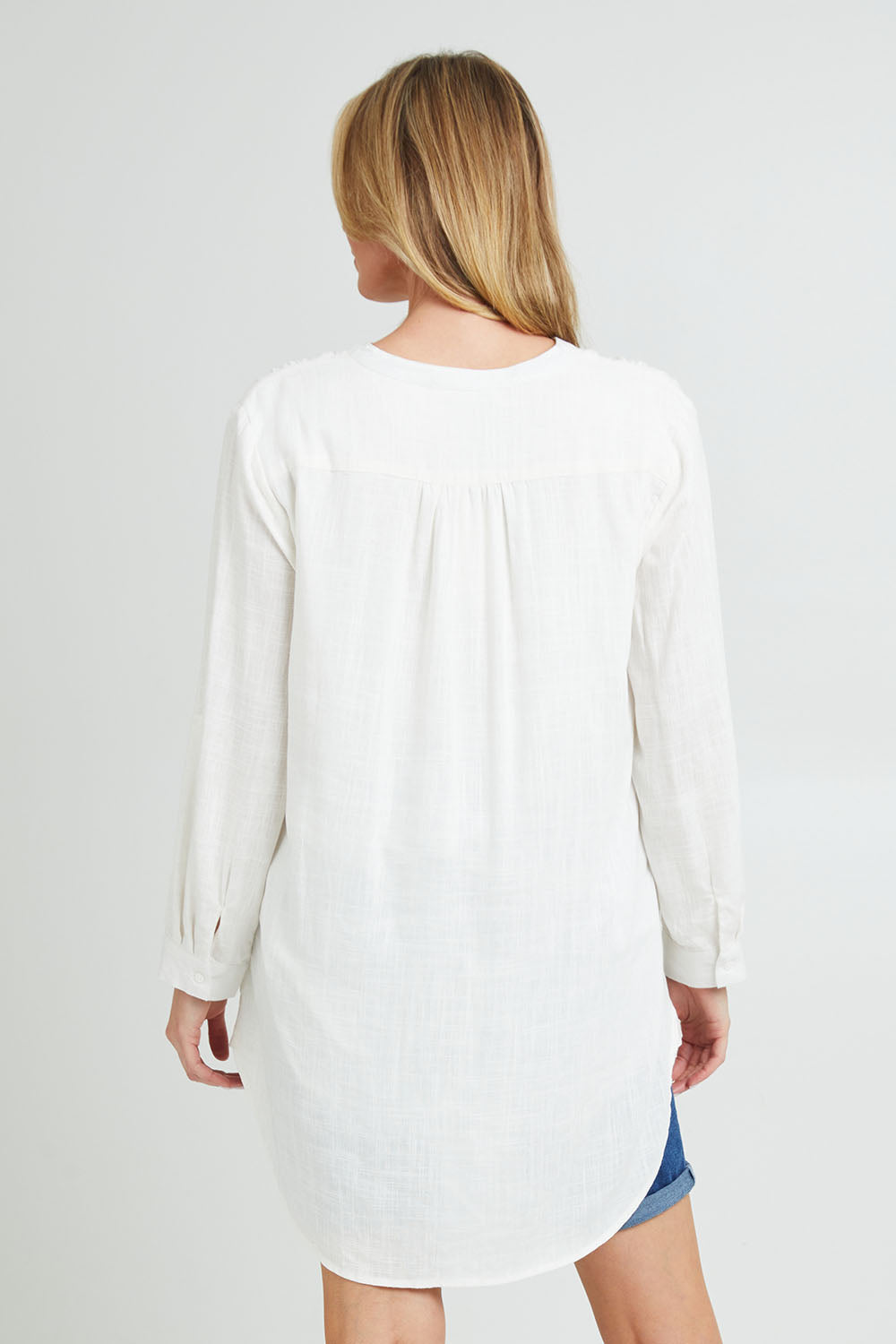 Model Grace wearing size 10 of the Beach Tunic Shirt in colour White (White), from the back