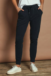 Model Madeline wearing size 10 of the Elements Lazy Days Pant in colour Navy (Blue), from the front, cropped image