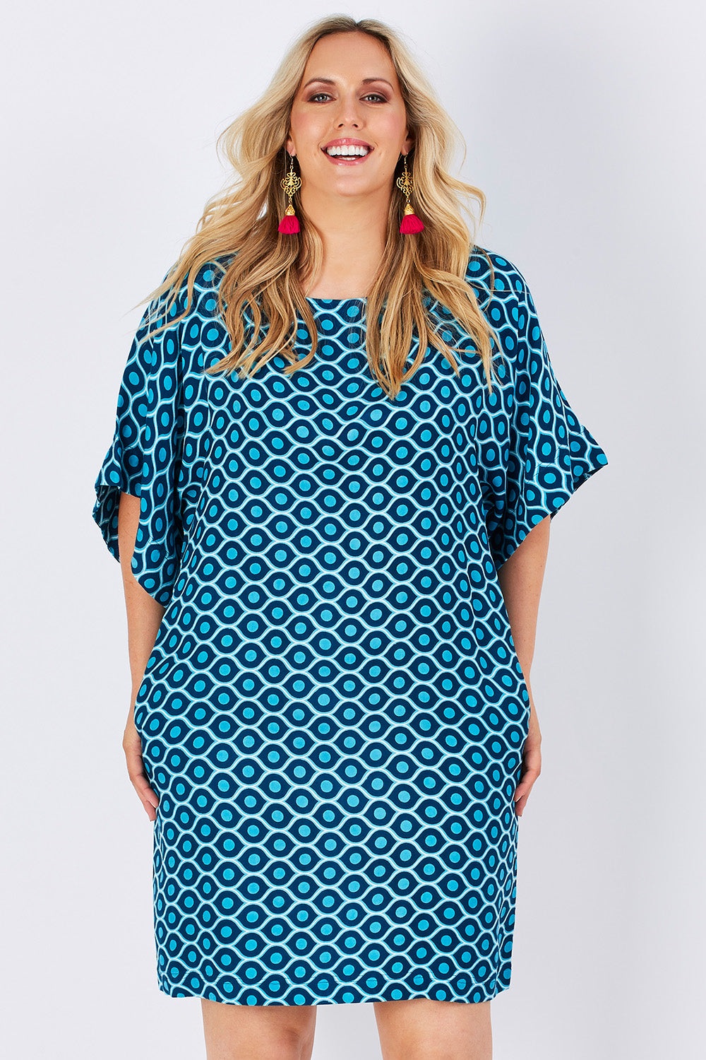Model Jess wearing size 14 of the Bell Sleeve Tunic Dress in colour TearDrop (Blue), from the front, cropped image