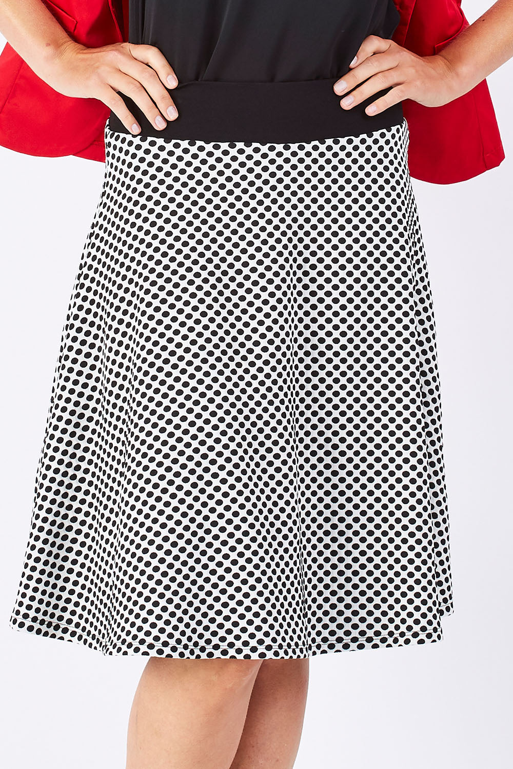 Model Jude wearing size 10 of the Spotted A Line Skirt in colour Spotted (White), from the front, cropped image